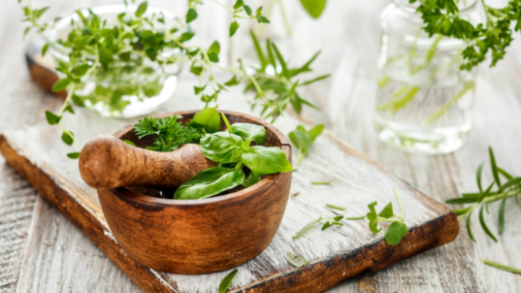 Image de fines herbes fraîches dans un mortier en bois sur une planche posée sur une table