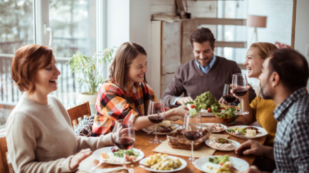 Personnes joyeuses assises autour d'une table dégustant un bon repas