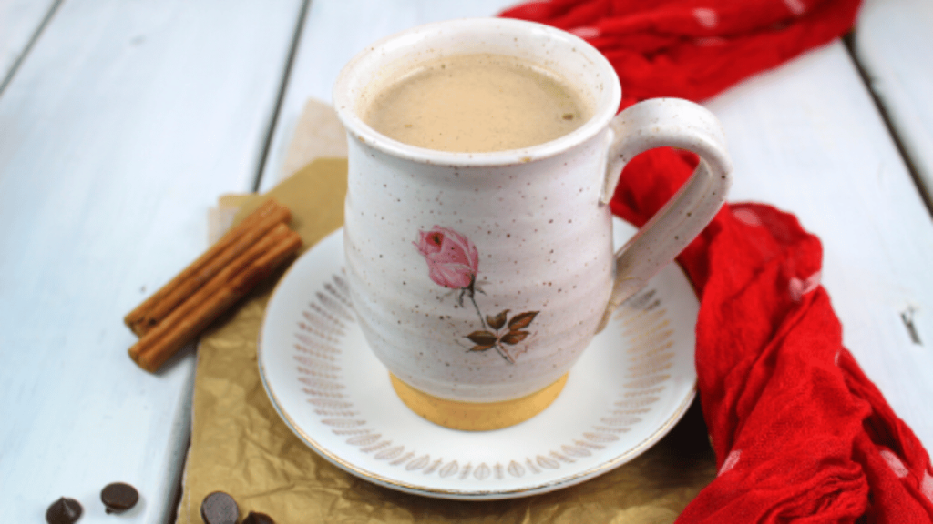 Tasse de boisson chaude au cacao sur une table blanche avec une serviette rouge et des bâtons de cannelle